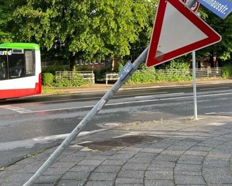 Ein Unfallort mit beschädigten Verkehrsschildern und einem Polizeiauto aufgrund eines Alkoholinfolgedelikt.