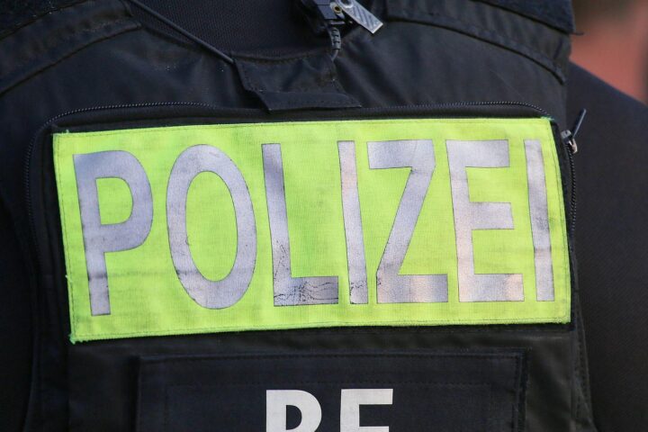 Polizei vor Kirche, Feuerwehr im Einsatz, Tatverdächtiger wird festgenommen nach Brandstiftung.