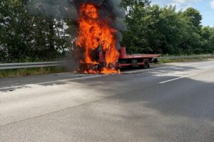 Brennender LKW auf Autobahn, Feuerwehr im Einsatz, starke Rauchentwicklung, Verkehr gesperrt.