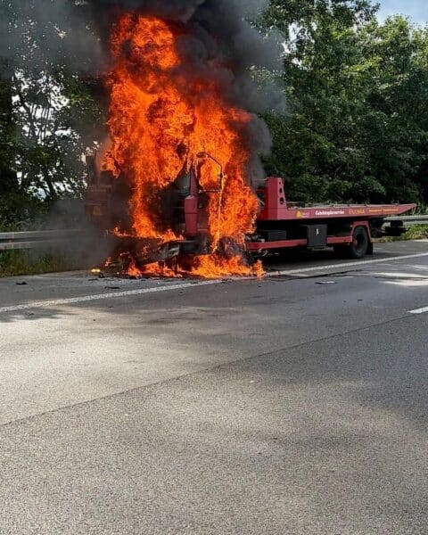 Brennender LKW auf Autobahn, Feuerwehr im Einsatz, starke Rauchentwicklung, Verkehr gesperrt.