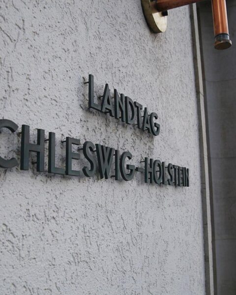 Landtag von Schleswig-Holstein mit Fokus auf Antidiskriminierungsgesetz, Symbol für Gleichheit und Gerechtigkeit.