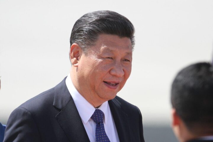 Xi Jinping bei Staatsbesuch in Nordkorea, umgeben von diplomatischen Symbolen und Flaggen.