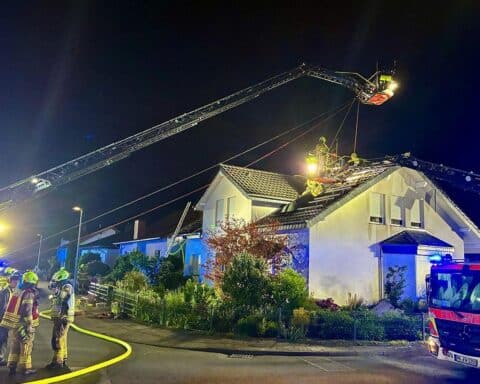 Dachstuhlbrand bei Einfamilienhaus, Feuerwehr im Einsatz, Flammen und Rauch sichtbar.