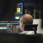Dax-Chart mit fallenden Kursen, Trader analysieren Märkte, Börse im Hintergrund, wirtschaftliche Unsicherheiten.