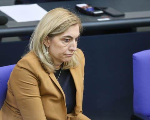 Nina Warken in einem Politiker-Setting, symbolisierende Reformen im Gesundheitssektor, besorgte Gesichter.