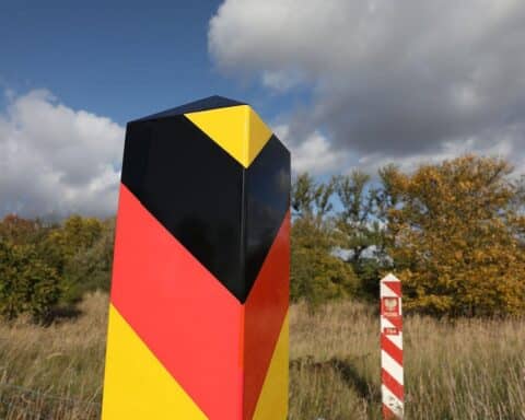 Deutsch-polnische Grenze mit Symbolen der Rückgabe kultureller Güter und historischer Verantwortung.