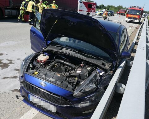 Autobahnunfall: beschädigter Ford, Rettungswagen, Verkehrsstau, verletzte Personen, Autobahnpolizei vor Ort.