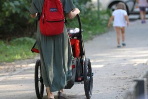 Eine Mutter mit Kind im Kinderwagen, symbolisiert steigendes Durchschnittsalter bei Geburten in NRW.