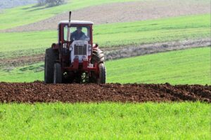 Bauer mit Traktor unterstützt durch EU-Maßnahmen gegen hohe Düngemittelpreise zur Sicherung der Ernährung.