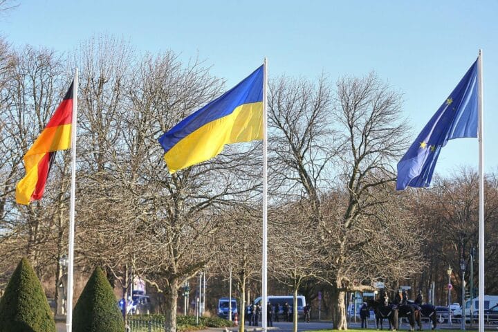 Fahnen von Deutschland, Ukraine und der EU symbolisieren den offiziellen Start der Beitrittsverhandlungen.