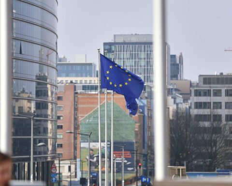 EU-Fahnen wehen vor dem Hintergrund von Brüssel, Symbol für neue Sanktionen gegen Russland.