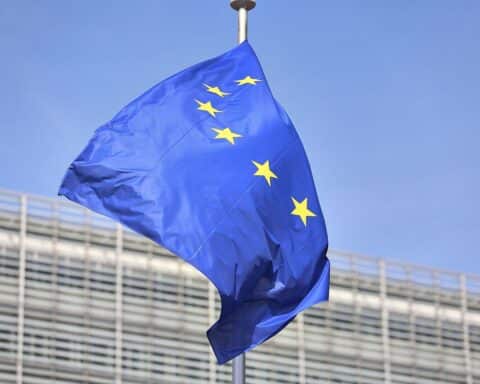 EU-Fahnen im Vordergrund, symbolisieren Partnerschaft und Fortschritt mit Afrika durch neues Abkommen.