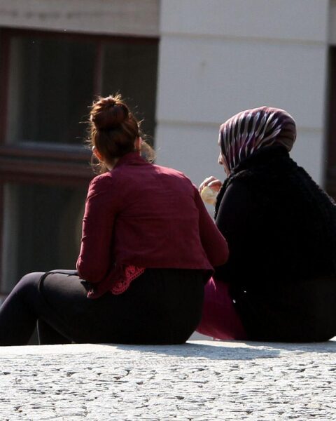 Zwei Frauen: eine mit, eine ohne Kopftuch, symbolisieren kulturelle Vielfalt und Integration in Deutschland.