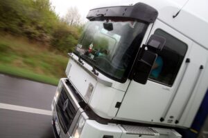 Ein Lkw steht vor einem Lagerhaus, symbolisiert steigende Kosten im Dienstleistungssektor.