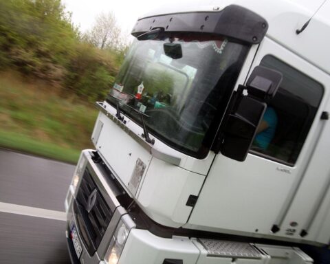 Ein Lkw steht vor einem Lagerhaus, symbolisiert steigende Kosten im Dienstleistungssektor.