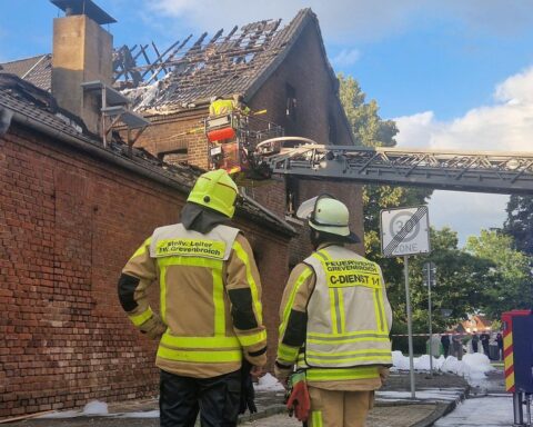 Feuerwehr im Einsatz, löschendes Gebäude, dichte Rauchentwicklung, besorgte Anwohner, mutmaßlicher Zimmerbrand.
