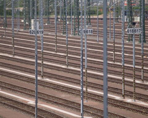 Zugfahrten gestört: Menschen warten an Gleisen, während Züge verspätet oder ausgefallen sind.