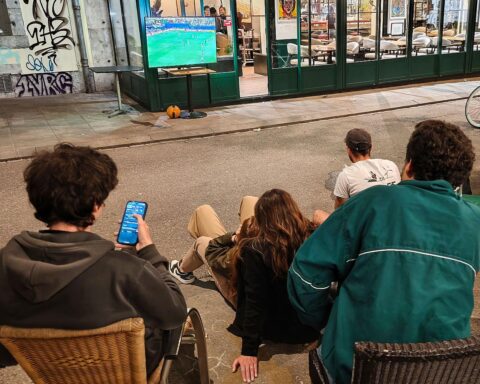 Fußballfans verfolgen begeistert ein Spiel auf der Straße während der Weltmeisterschaft.
