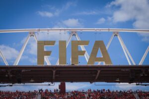 Kolumbianischer Spieler feiert Sieg, FIFA-Logo im Hintergrund, Fußball-Weltmeisterschaft im Fokus.