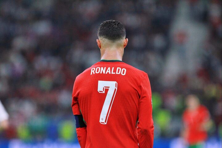 Cristiano Ronaldo jubelt nach einem Tor, umgeben von feiernden Portugiesen im Stadion.