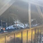 Feuerwehr löscht Garagenbrand, schützt angrenzendes Wohnhaus, Einsatzkräfte bei Aufräumarbeiten.