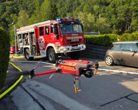 Feuerwehr im Einsatz bei Gasaustritt, Einsatzkräfte mit Wassernebel, Sicherheitsbereich abgesperrt.