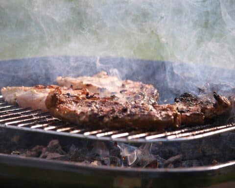 Ein Grill mit Steak in einem Park, symbolisiert das Verbot wegen Trockenheit und Feuergefahr.