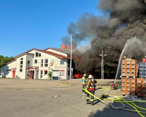 Großbrand im Feuerwehrhaus Unterensingen: Zerstörtes Gebäude, Rettungskräfte im Einsatz, flammende Rückstände.