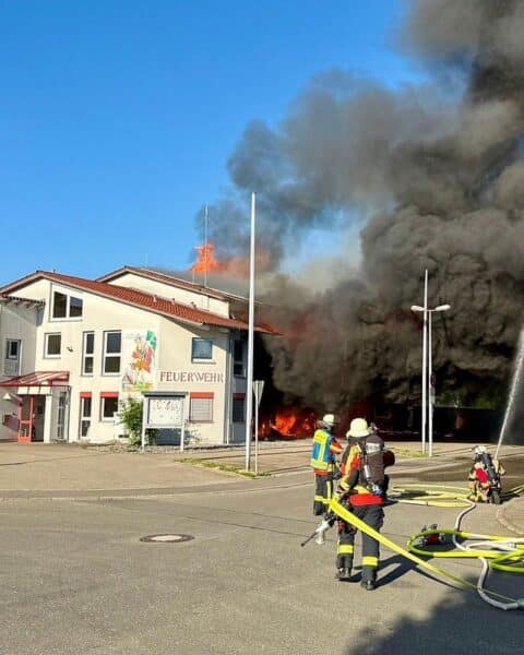 Großbrand im Feuerwehrhaus Unterensingen: Zerstörtes Gebäude, Rettungskräfte im Einsatz, flammende Rückstände.