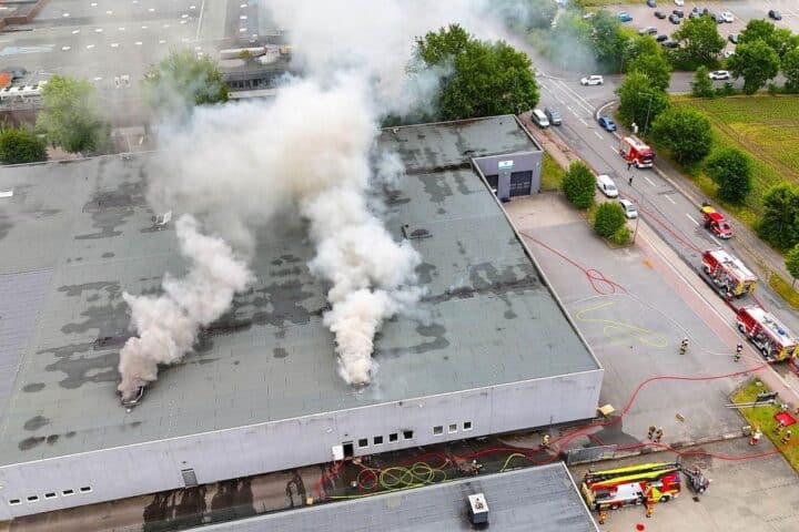 Intensive Rauchentwicklung, Feuerwehr im Einsatz, Brandbekämpfung in Lagerhalle mit Elektroartikeln und Kunststoff.