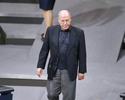 Gregor Gysi, umgeben von Rednerpult und Publikum, verteidigt Nebeneinkünfte als Bundestagsabgeordneter.