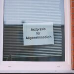 Hausärztin berät Patientin über Hitzeschutzmaßnahmen in einer Arztpraxis während Hitzewelle.