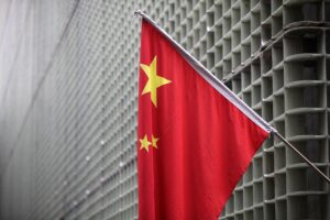 Chinesische Flagge vor wissenschaftlichem Hintergrund, symbolisiert Forschung und internationale Spannungen.