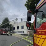 Großbrand in Produktionshalle, Feuerwehr im Einsatz, starke Rauchentwicklung, Gefahr für Anwohner.