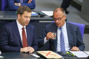 Politiker Lars Klingbeil und Friedrich Merz diskutieren über Umfrageergebnisse in Berlin.