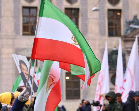 Protestierende Menschen halten Schilder, um gegen das iranische Regime und US-Iran-Beziehungen zu demonstrieren.