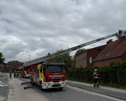 Feuerwehr im Einsatz zur Bekämpfung eines Kaminbrands in einem Mehrfamilienhaus.