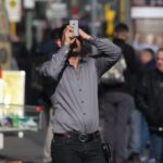 Mann mit Smartphone nutzt kostenloses WLAN in Bernburg, symbolisiert digitale Fortschritte für Tourismus.