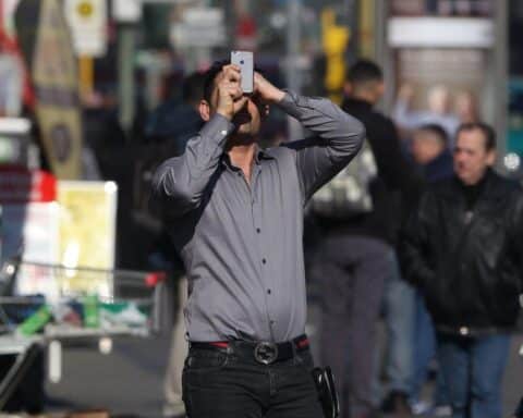 Mann mit Smartphone nutzt kostenloses WLAN in Bernburg, symbolisiert digitale Fortschritte für Tourismus.