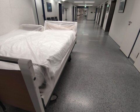 Ein überlastetes Krankenhaus bei extremer Hitze, das Mangel an Investitionen und Hitzeschutz symbolisiert.