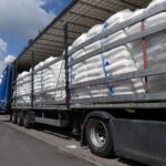 Sattelzug mit schräg stehender Ladung auf Rastplatz, Polizei kontrolliert unzureichende Ladungssicherung.