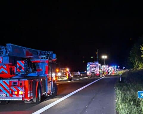 Schwerer Verkehrsunfall auf Autobahn, Feuerwehr im Einsatz, verunfalltes Fahrzeug im Graben.