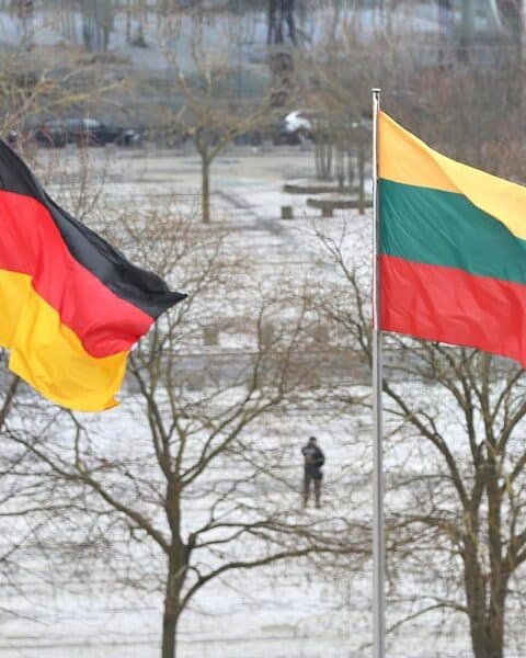 Fahnen von Deutschland und Litauen, symbolisieren politische Spannungen und historische Konflikte im Kontext des Zweiten Weltkriegs.