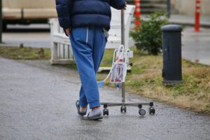 Patient im Krankenhaus mit Infusionsständer, symbolisiert Pflegekosten und Herausforderungen für Familien in Deutschland.