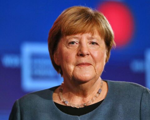 Angela Merkel posiert für ihr Porträt in der Ahnengalerie, kunstvoll und nachdenklich.