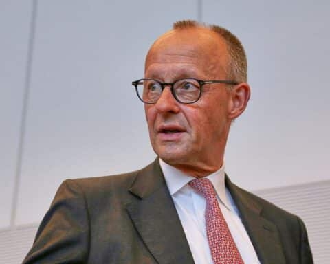 Friedrich Merz diskutiert den Irak-Krieg und NATO-Strategien während eines politischen Treffens.