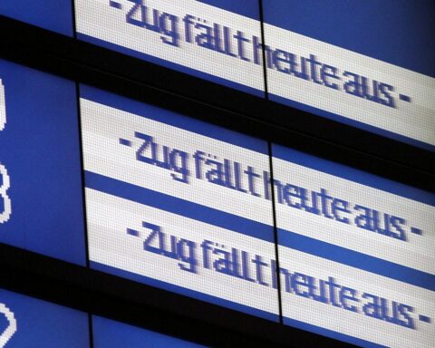 Ein defekter Zug, der stillsteht, während Techniker an digitalen Systemen arbeiten.