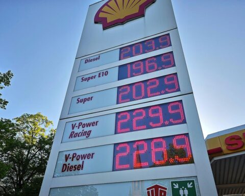 Tankstelle mit Preisanzeige, die sinkende Kraftstoffpreise und Tankrabatt hervorhebt.