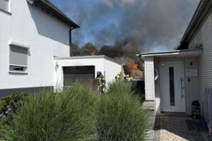 Garagenbrand in Witten-Heven, Feuerwehr im Einsatz zum Schutz benachbarter Wohnhäuser.