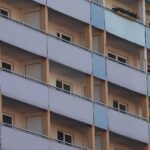Wohngeldkürzungen gefährden hunderttausende Haushalte; Bewohner vor ihrem Wohnhaus in besorgter Stimmung.
